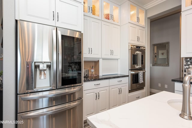 2092 Canterbury Ln, Carson City, NV 89703 - kitchen with stainless steel appliances, white cabinets, dark stone countertops, and glass insert cabinets