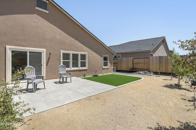 6496 Arc Dome Dr, Carson City, NV 89701 - back of property with a fenced backyard, stucco siding, and a patio area