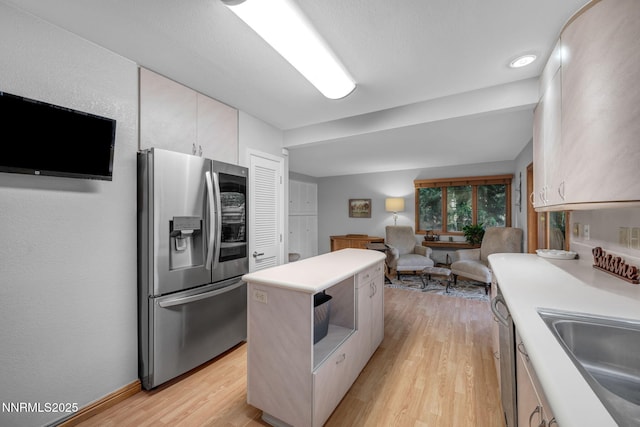 6437 Meadow Valley Ln, Reno, NV 89519 - kitchen with stainless steel fridge, light wood-style flooring, light countertops, a kitchen island, and open floor plan