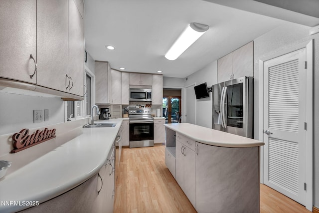 6437 Meadow Valley Ln, Reno, NV 89519 - kitchen featuring appliances with stainless steel finishes, a kitchen island, light wood-style floors, light countertops, and recessed lighting