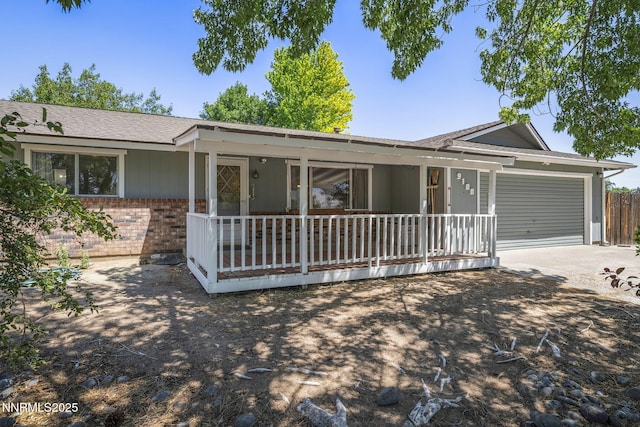9100 Rain Dance Way, Reno, NV 89506 - ranch-style home with brick siding, a garage, concrete driveway, covered porch, and roof with shingles