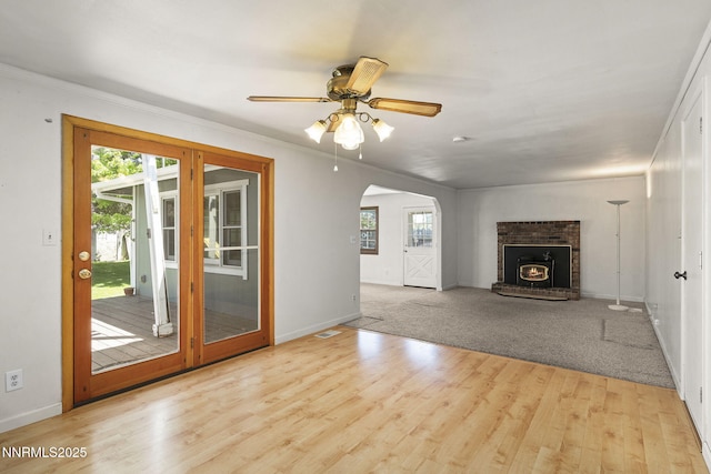 9100 Rain Dance Way, Reno, NV 89506 - unfurnished living room with healthy amount of natural light, arched walkways, wood finished floors, a fireplace, and ornamental molding
