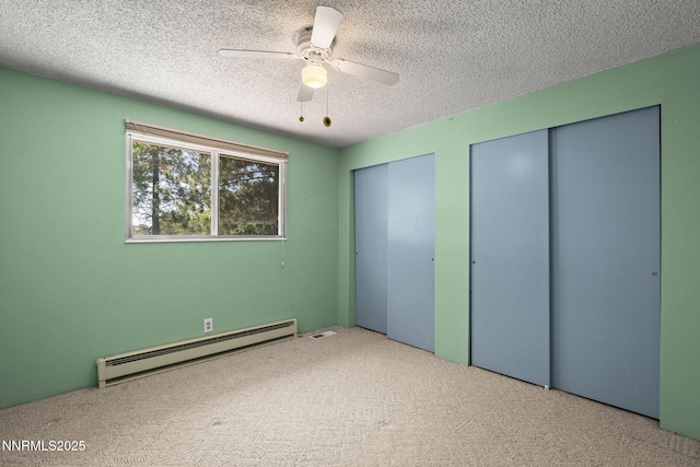 9100 Rain Dance Way, Reno, NV 89506 - unfurnished bedroom with a baseboard heating unit, multiple closets, carpet flooring, a textured ceiling, and a ceiling fan