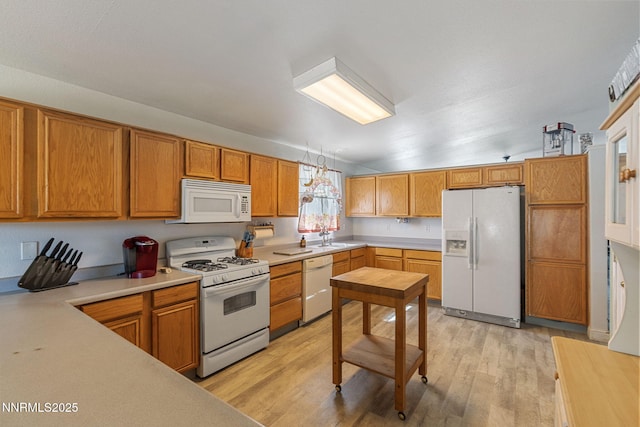 5886 Wishbone Ct, Sun Valley, NV 89433 - kitchen with white appliances, light wood finished floors, light countertops, and brown cabinetry