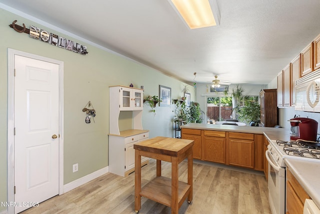 5886 Wishbone Ct, Sun Valley, NV 89433 - kitchen featuring white appliances, light wood finished floors, light countertops, and ceiling fan