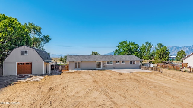1314 Johnson Ln, Minden, NV 89423 - back of property featuring an outdoor structure, a detached garage, a gambrel roof, and a mountain view