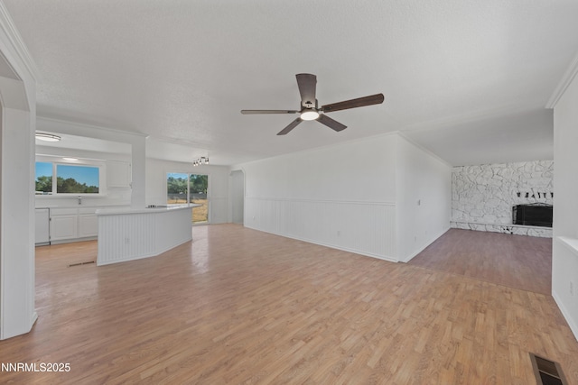 1314 Johnson Ln, Minden, NV 89423 - unfurnished living room with ceiling fan, a fireplace, light wood-style floors, a wainscoted wall, and ornamental molding