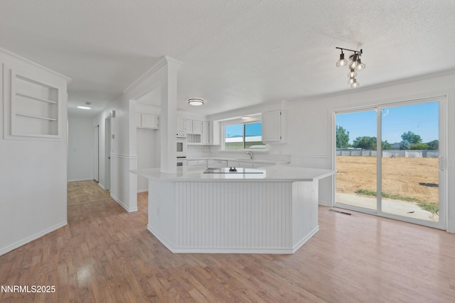 1314 Johnson Ln, Minden, NV 89423 - kitchen with light countertops, white cabinets, light wood-style floors, a textured ceiling, and black electric stovetop
