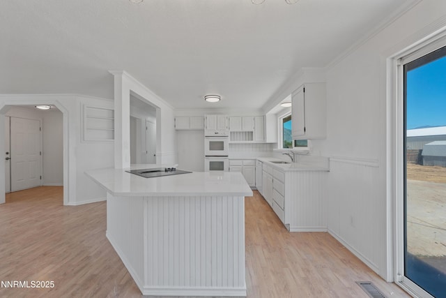 1314 Johnson Ln, Minden, NV 89423 - kitchen featuring white double oven, black electric cooktop, light wood-style flooring, light countertops, and white cabinets