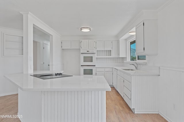 1314 Johnson Ln, Minden, NV 89423 - kitchen featuring black electric cooktop, white double oven, white cabinetry, and crown molding