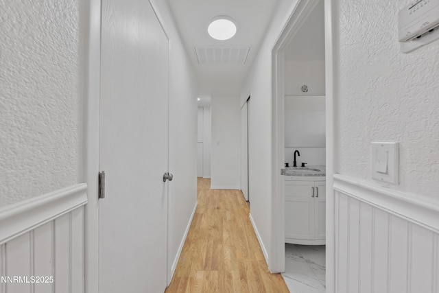 1314 Johnson Ln, Minden, NV 89423 - corridor featuring a textured wall, light wood-type flooring, and a wainscoted wall