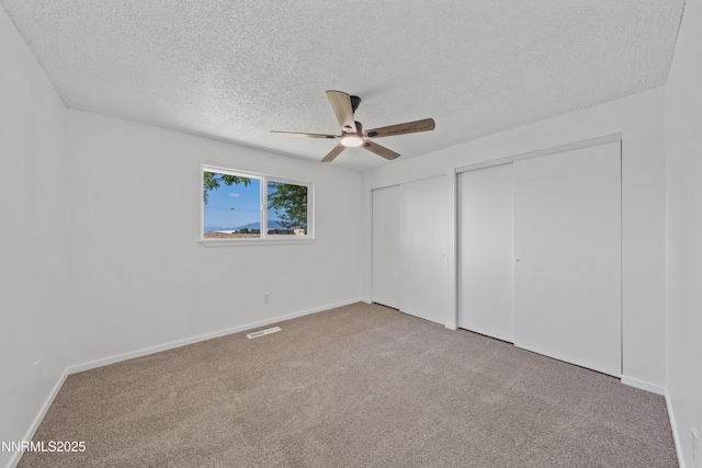 1314 Johnson Ln, Minden, NV 89423 - unfurnished bedroom with two closets, a textured ceiling, carpet floors, and a ceiling fan