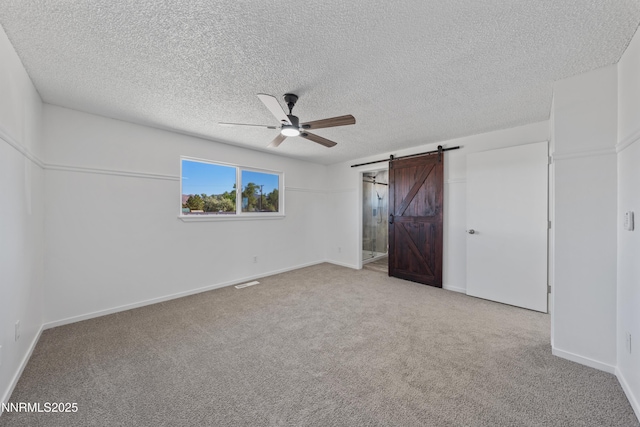 1314 Johnson Ln, Minden, NV 89423 - unfurnished bedroom with carpet floors, a barn door, a textured ceiling, and ceiling fan