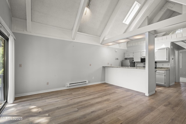 989 Tahoe Blvd Unit 71, Incline Village, NV 89451 - kitchen featuring a baseboard radiator, stainless steel microwave, fridge, beamed ceiling, and wood finished floors