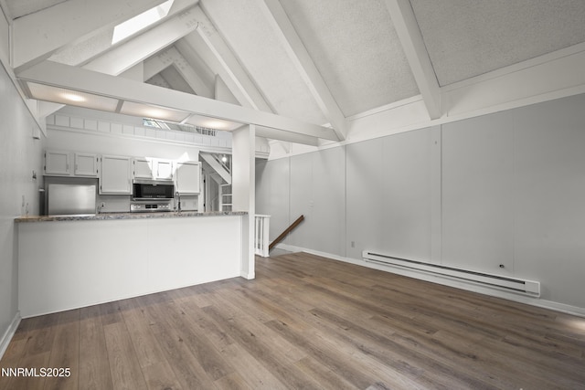 989 Tahoe Blvd Unit 71, Incline Village, NV 89451 - unfurnished living room featuring baseboard heating, a skylight, wood finished floors, and a decorative wall