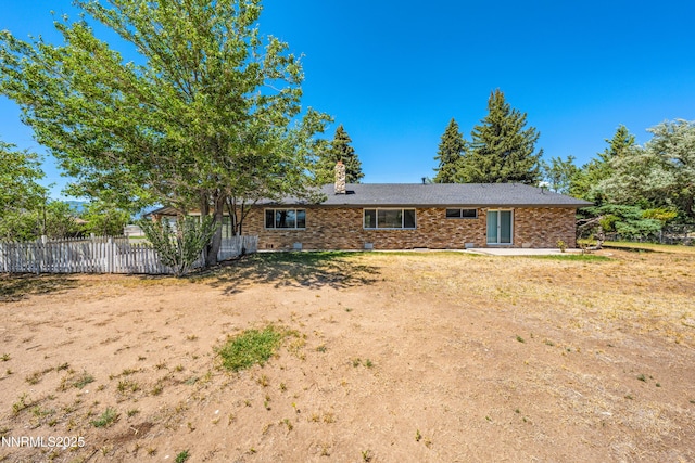 1513 S Riverview Dr, Gardnerville, NV 89460 - rear view of house with brick siding, a chimney, and a patio