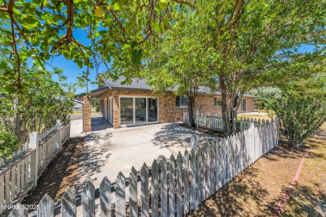 1513 S Riverview Dr, Gardnerville, NV 89460 - rear view of property featuring a fenced backyard, brick siding, and a patio area