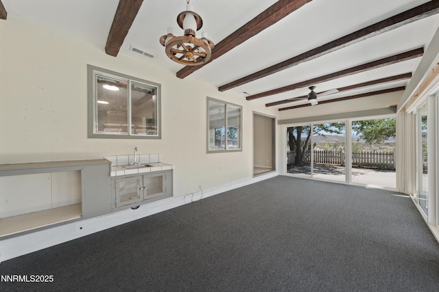 1513 S Riverview Dr, Gardnerville, NV 89460 - unfurnished living room featuring beam ceiling, carpet floors, a chandelier, and a ceiling fan