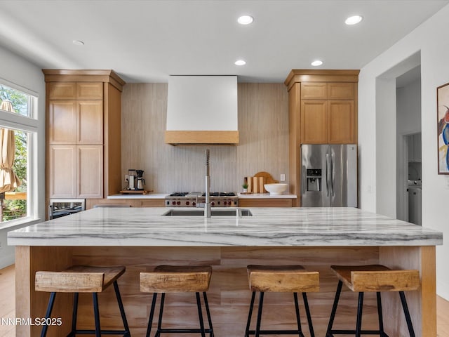 4721 W Creek Ridge Trl, Reno, NV 89519 - kitchen featuring stainless steel fridge with ice dispenser, custom exhaust hood, light stone countertops, recessed lighting, and a center island with sink