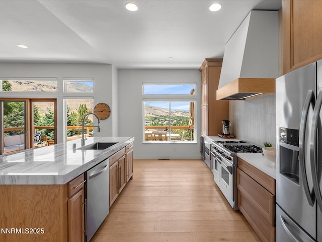 4721 W Creek Ridge Trl, Reno, NV 89519 - kitchen with stainless steel appliances, custom exhaust hood, light wood-type flooring, recessed lighting, and light stone counters
