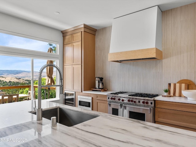 4721 W Creek Ridge Trl, Reno, NV 89519 - kitchen with custom range hood, double oven range, a mountain view, and light stone countertops
