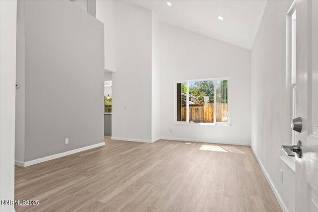 2719 Chavez Dr, Reno, NV 89502 - unfurnished living room with light wood finished floors, high vaulted ceiling, and recessed lighting