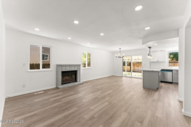 2719 Chavez Dr, Reno, NV 89502 - unfurnished living room with a chandelier, recessed lighting, light wood-style floors, and a brick fireplace