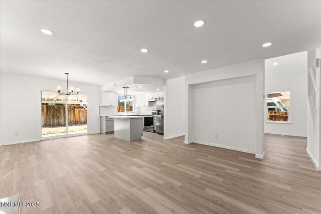 2719 Chavez Dr, Reno, NV 89502 - unfurnished living room with a chandelier, recessed lighting, and light wood-type flooring