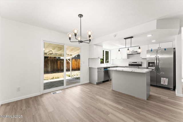 2719 Chavez Dr, Reno, NV 89502 - kitchen featuring stainless steel appliances, light wood-type flooring, a chandelier, under cabinet range hood, and recessed lighting