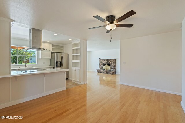 2095 Kings Row, Reno, NV 89503 - unfurnished living room with light wood-type flooring, a ceiling fan, a stone fireplace, and recessed lighting