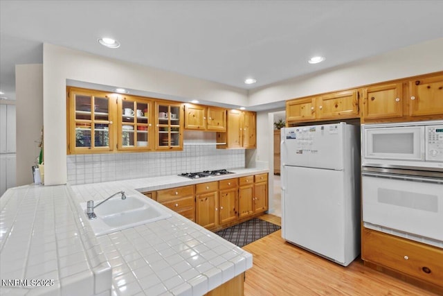 917 Jennifer St, Incline Village, NV 89451 - kitchen featuring white appliances, tile countertops, light wood-style flooring, tasteful backsplash, and glass insert cabinets
