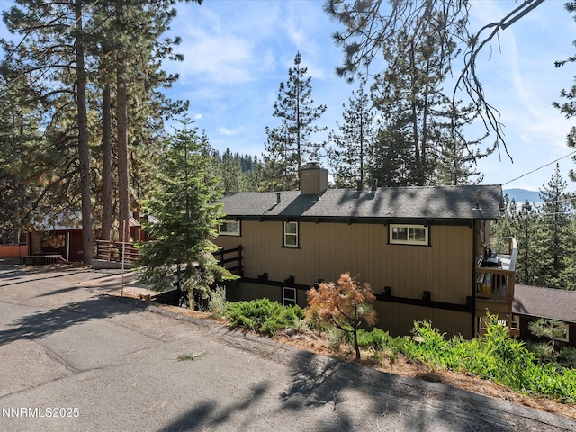 699 Lakeview Dr, Zephyr Cove, NV 89448 - view of side of home featuring a chimney and roof with shingles