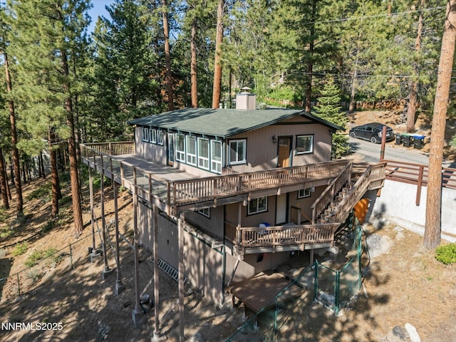 699 Lakeview Dr, Zephyr Cove, NV 89448 - rear view of house with a wooden deck, stairs, roof with shingles, a chimney, and a wooded view