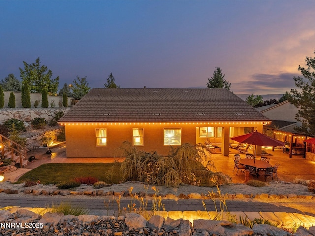 1486 Lambrays Ct, Sparks, NV 89436 - back of house at dusk with a patio and outdoor dining space