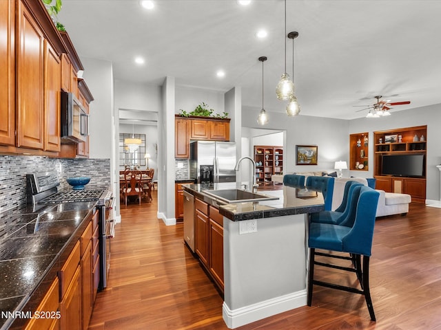 1486 Lambrays Ct, Sparks, NV 89436 - kitchen featuring stainless steel appliances, brown cabinets, open floor plan, a ceiling fan, and dark wood-style floors