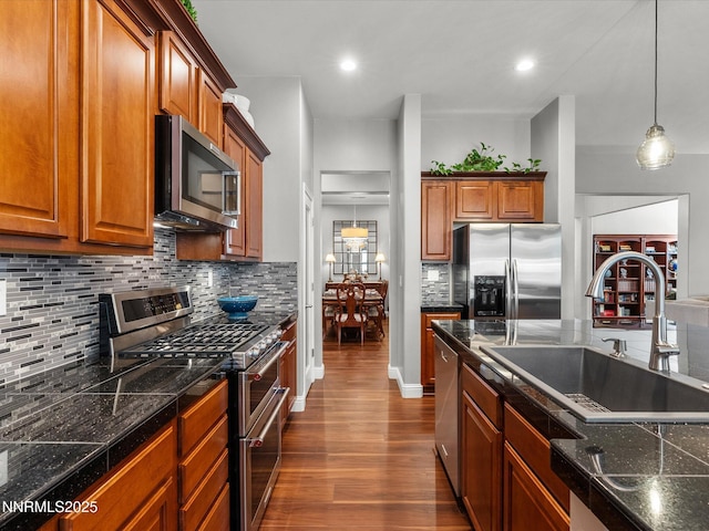 1486 Lambrays Ct, Sparks, NV 89436 - kitchen featuring stainless steel appliances, dark wood-type flooring, tasteful backsplash, brown cabinetry, and decorative light fixtures