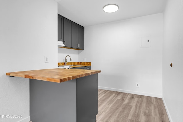 2450 Lymbery St Unit 331, Reno, NV 89509 - kitchen featuring butcher block counters, light wood-type flooring, dark cabinets, a kitchen breakfast bar, and electric panel