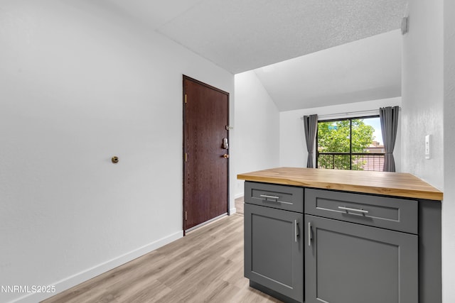 2450 Lymbery St Unit 331, Reno, NV 89509 - kitchen featuring butcher block counters, gray cabinets, vaulted ceiling, and light wood-type flooring
