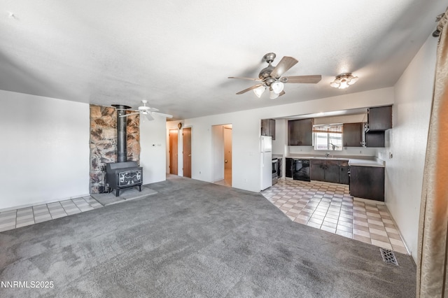 8720 Aquifer Way, Reno, NV 89506 - unfurnished living room featuring a ceiling fan, light tile patterned flooring, light carpet, and a wood stove