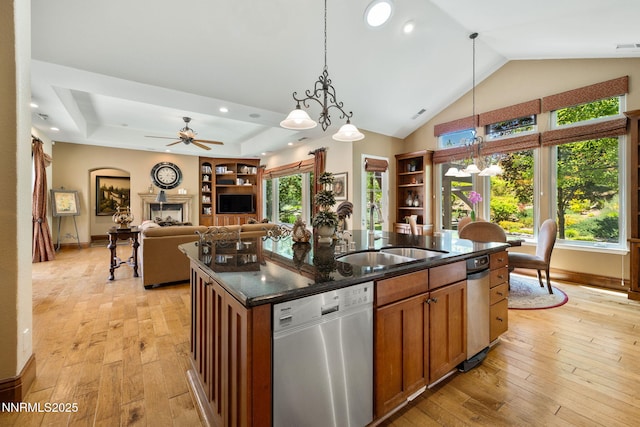 16956 Rue Du Parc Ave, Reno, NV 89511 - kitchen featuring stainless steel dishwasher, light wood-style floors, decorative light fixtures, an island with sink, and lofted ceiling