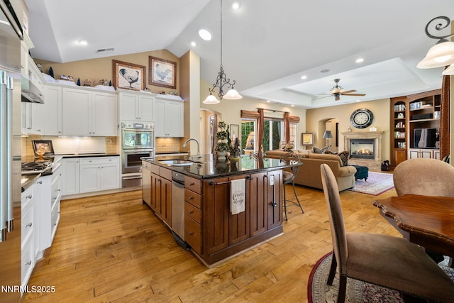 16956 Rue Du Parc Ave, Reno, NV 89511 - kitchen with appliances with stainless steel finishes, dark countertops, ceiling fan, white cabinetry, and high vaulted ceiling