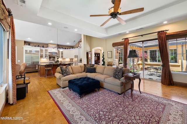 16956 Rue Du Parc Ave, Reno, NV 89511 - living room with light wood-style flooring, recessed lighting, arched walkways, ceiling fan, and a raised ceiling