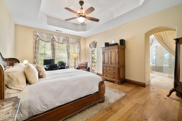 16956 Rue Du Parc Ave, Reno, NV 89511 - bedroom with a raised ceiling, arched walkways, light wood finished floors, ensuite bath, and a ceiling fan