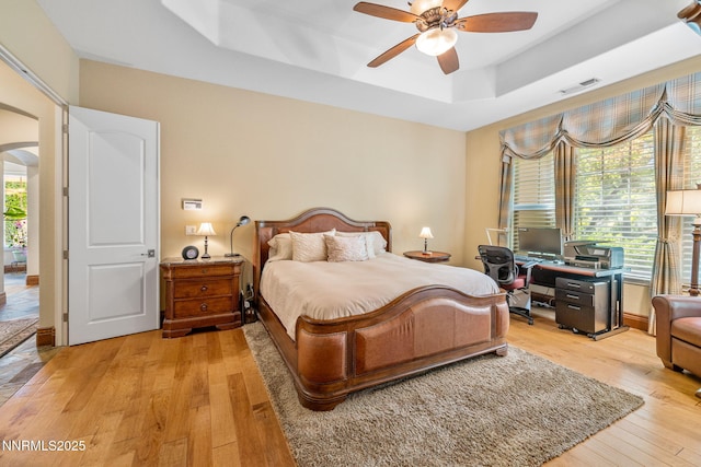 16956 Rue Du Parc Ave, Reno, NV 89511 - bedroom with arched walkways, a raised ceiling, light wood-style flooring, an office area, and a ceiling fan