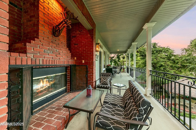 171 Mill St, Genoa, NV 89411 - balcony at dusk with an outdoor brick fireplace and covered porch