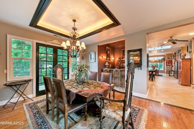 171 Mill St, Genoa, NV 89411 - dining room featuring a chandelier, a raised ceiling, light wood-type flooring, and ceiling fan