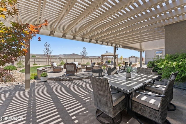 10 Diamond Strm Ct, Sparks, NV 89441 - fenced backyard with an outdoor living space with a fire pit, outdoor dining space, a pergola, a patio, and a mountain view