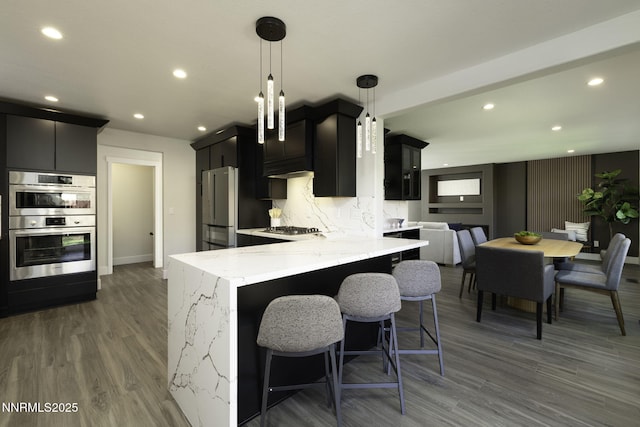 3323 Deer Ridge Ct, Reno, NV 89509 - kitchen featuring appliances with stainless steel finishes, dark cabinets, recessed lighting, dark wood-style flooring, and light stone countertops