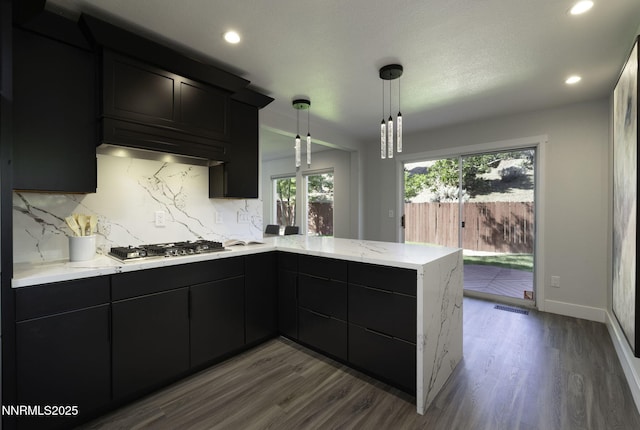3323 Deer Ridge Ct, Reno, NV 89509 - kitchen with dark cabinetry, dark wood-style floors, backsplash, a peninsula, and recessed lighting