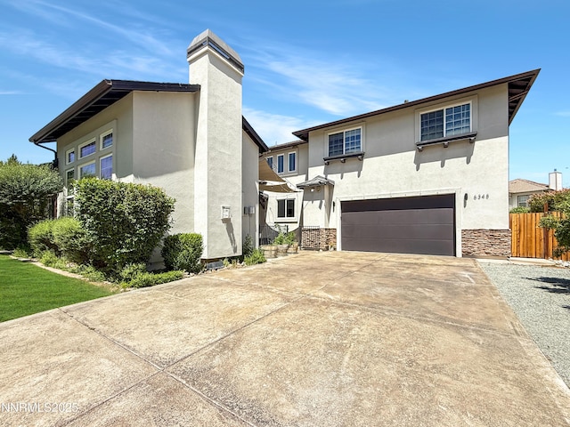 6348 Chilhowee Ct, Sparks, NV 89436 - view of front of house with stucco siding, an attached garage, driveway, stone siding, and a chimney